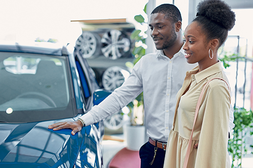 A couple check out an older used vehicle they are thinking of buying with an older used auto loan.