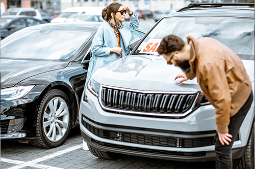 A couple check out a used vehicle they are thinking of buying with a used auto loan.