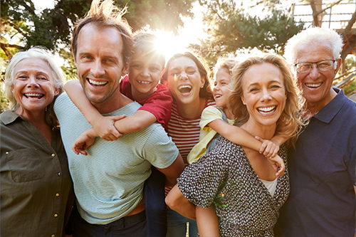 Grandparents celebrating with their children and grandchildren, enjoying quality time together, thanks to their successful retirement savings in an IRA.